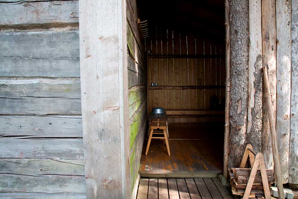 Tunnelma kuva, jossa savusaunan seinustaa ja pesujakkara