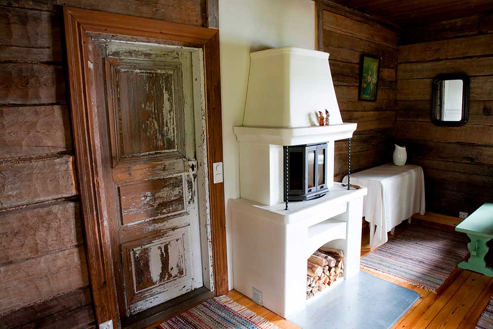 Savusaunan oleskelutila, jossa valkoinen takka